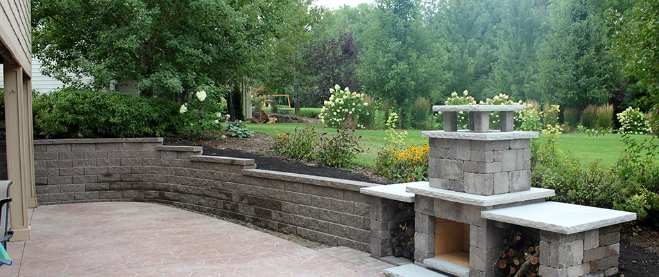 Retaining wall and fire pit installed over patio in Waukee, IA.