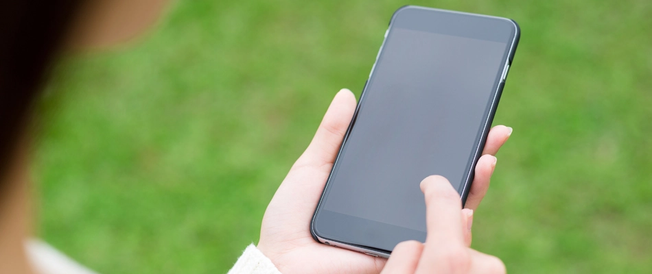 Homeowner using phone to control bluetooth landscape lights in Urbandale, IA.