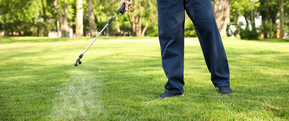 A technician applying lawn treatments to a property in Grimes, IA.